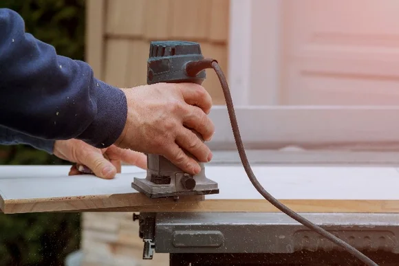 Person fräst Holz mit Oberfräse